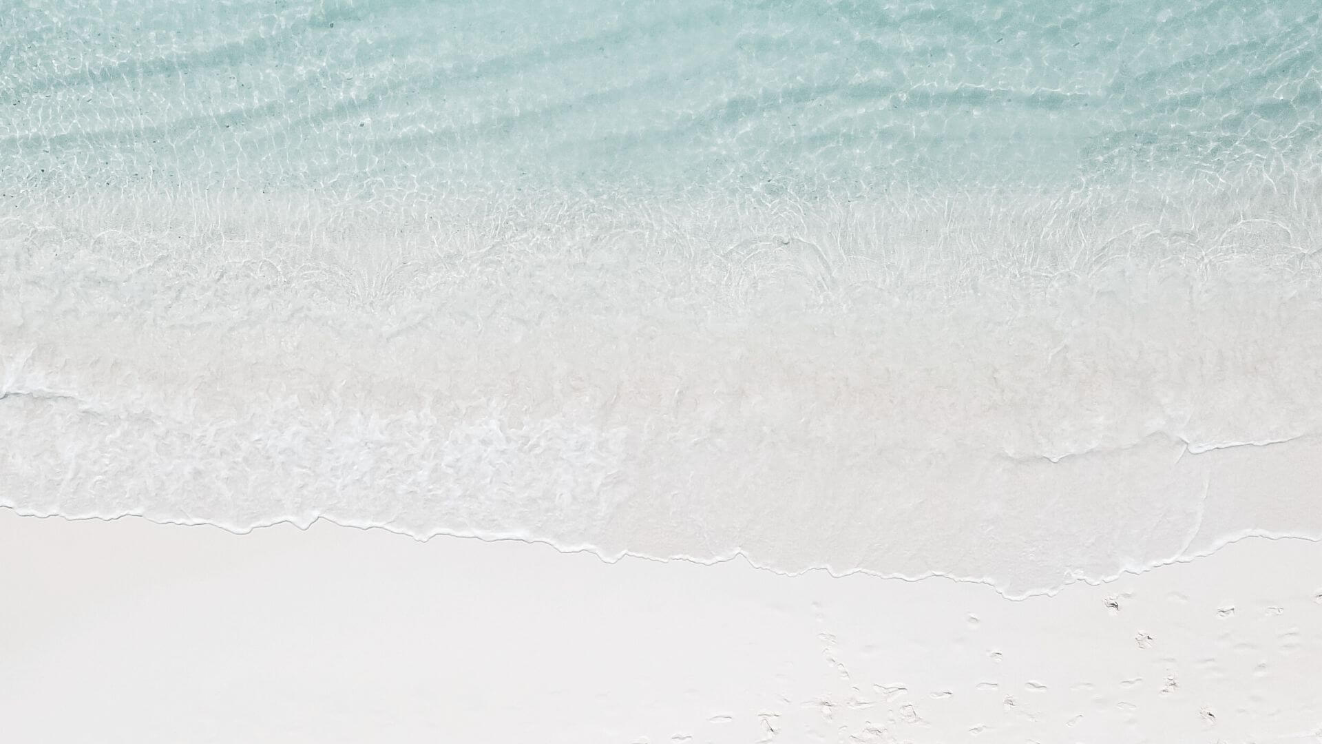Bildbanner für über uns-Seite zeigt Strand von oben