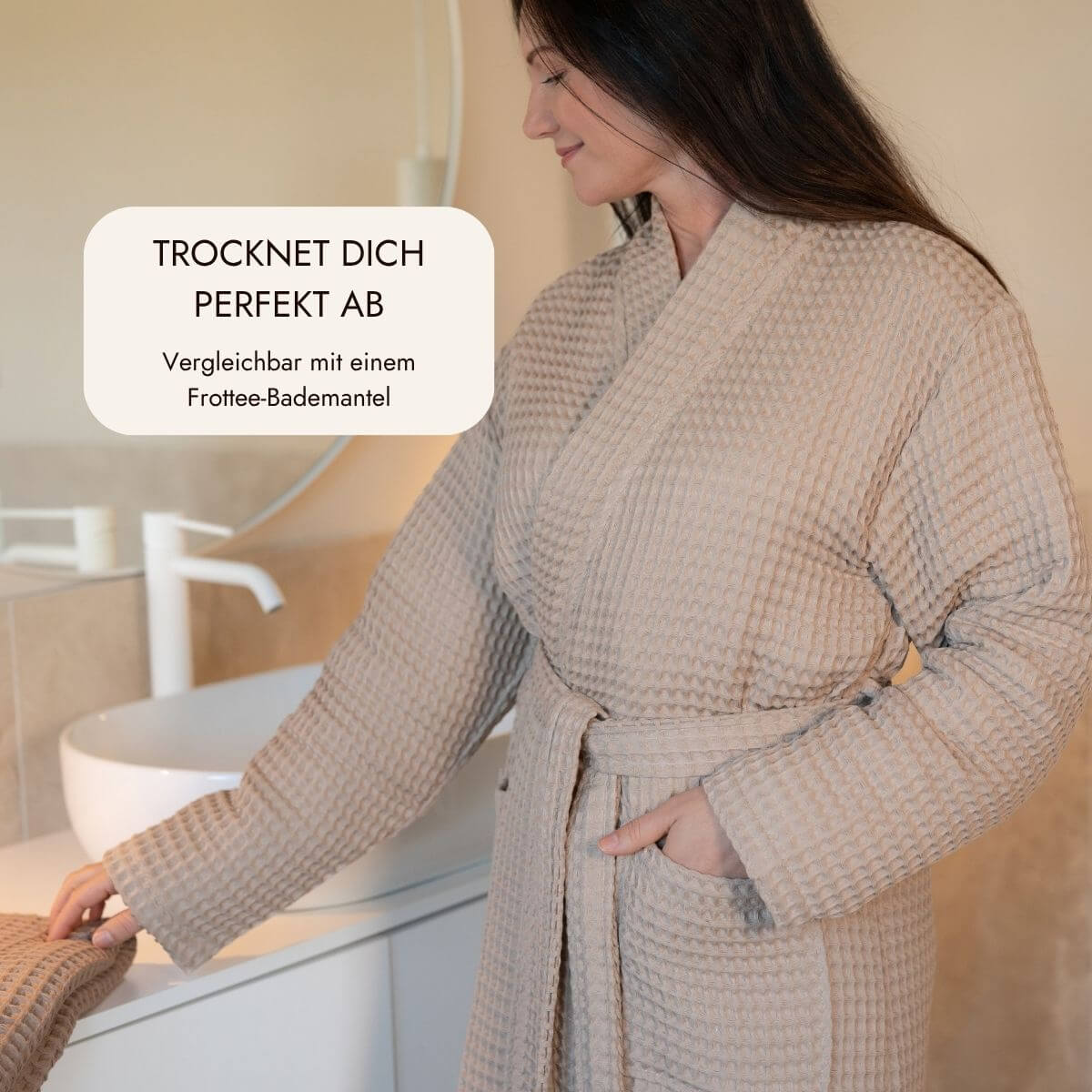 Frau im Waffelpiqué-Bademantel in Coffee am Waschtisch im Badezimmer – trocknet so gut ab wie Frottee
