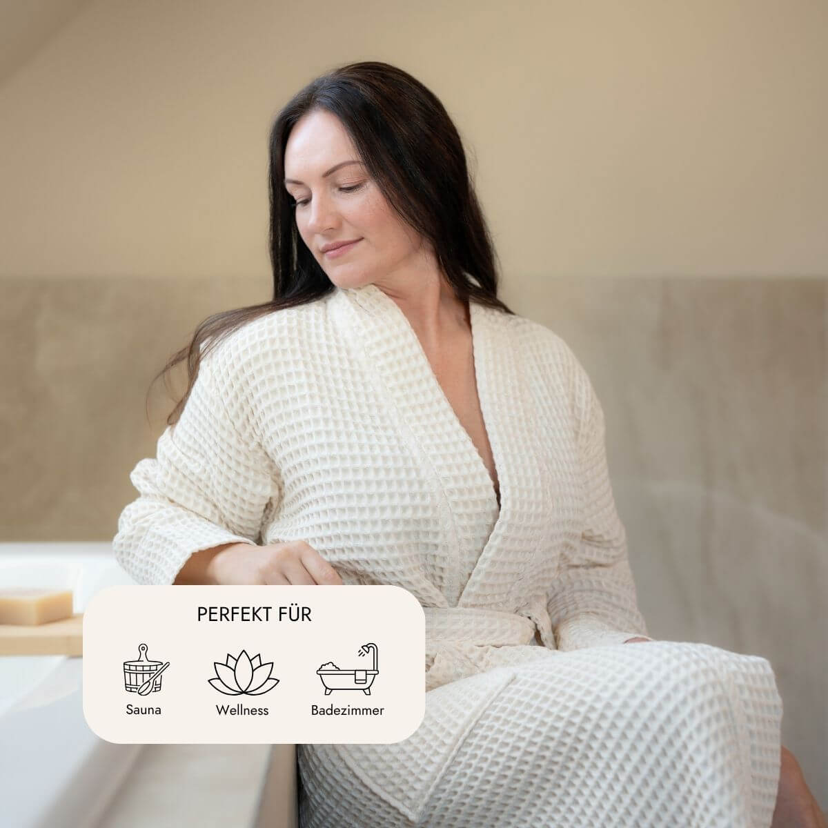 Frau im Kimono-Bademantel in Natur sitzt entspannt am Badewannenrand – ideal für Sauna, Wellness und Badezimmer