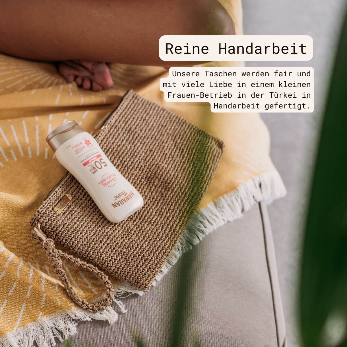VAYVA Raffia-Clutch mit Sonnencreme auf gelbem Strandtuch – faire Handarbeit aus der Türkei